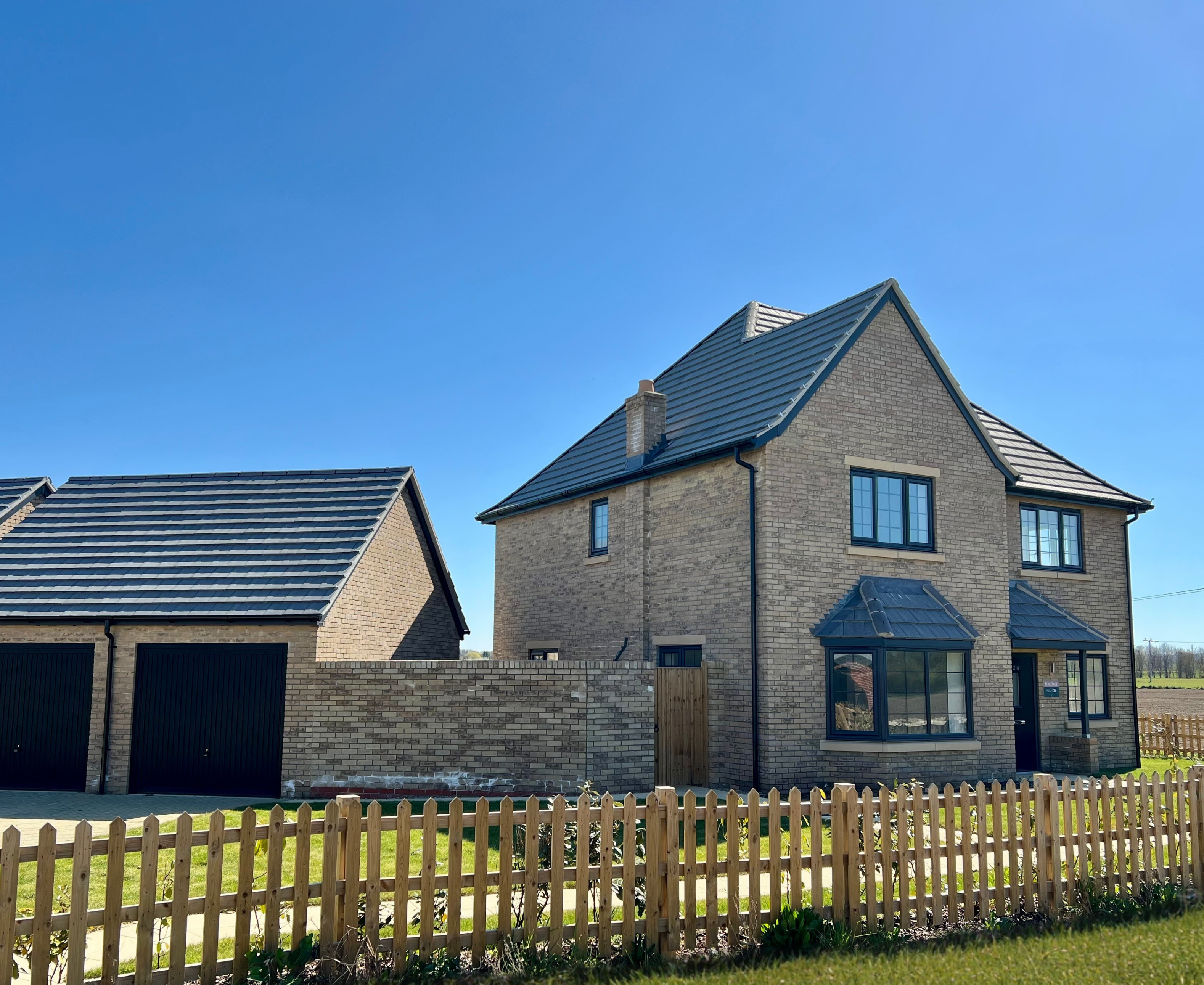 A new build two storey house with garage with a fence running along side