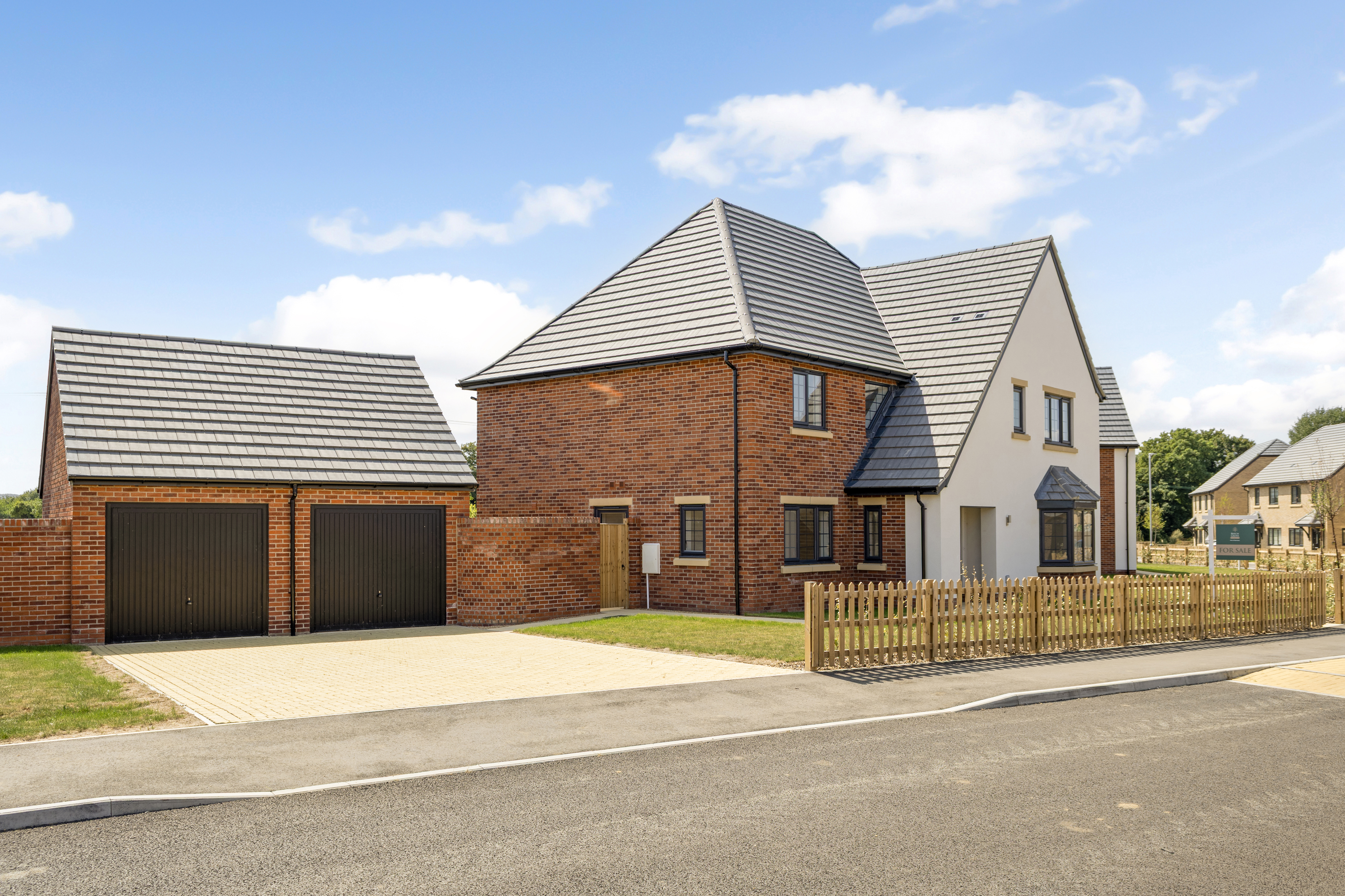  Stylish newly built two-story home with red brick and white exterior, grey tiled roof, and large windows. Includes a detached double garage, paved driveway, and wooden picket fence.