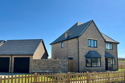 A new build two storey house with garage with a fence running along side