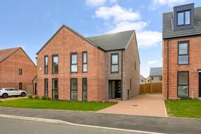 Four-bedroom family home at Southfields new-build development with driveway and contemporary brick design.