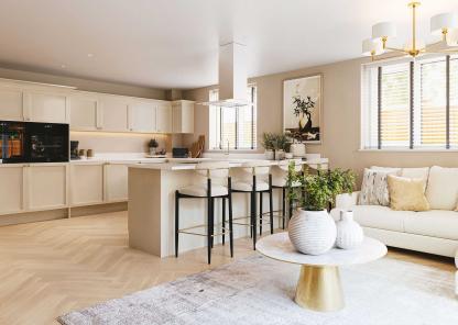  Contemporary kitchen and living space with cream cabinets, a breakfast bar with three stools, a white sofa, a round coffee table with decorative vases, and large windows allowing natural light to fill the room.